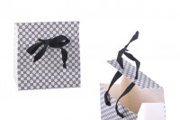 Paper gift bag in a special design and print with a 10mm grosgrain ribbon bow tie handle in size 105x67x105