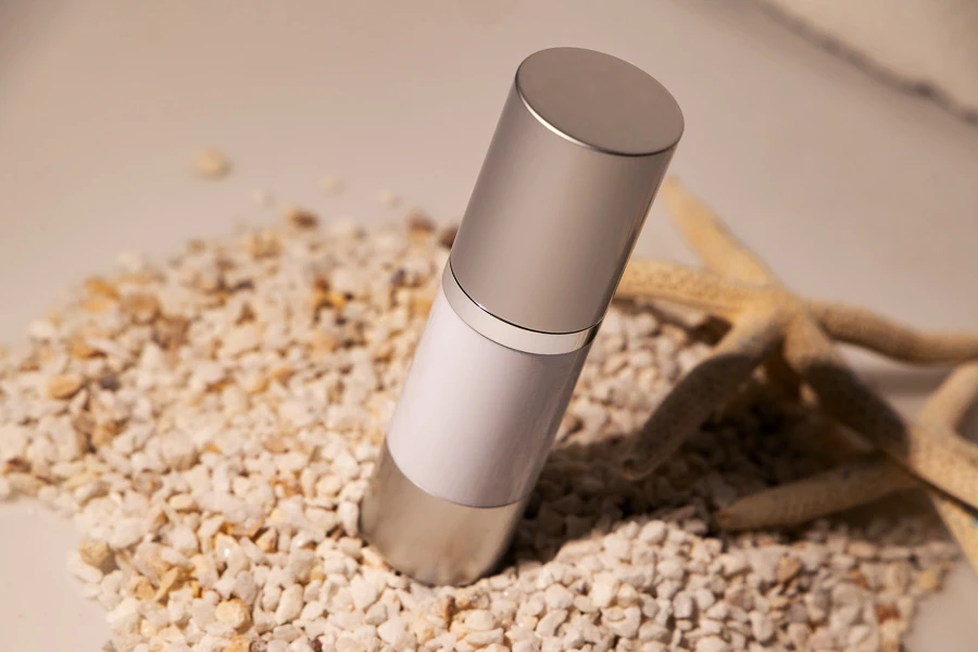 Bottiglia airless da 30 ml per crema con corpo bianco in plastica, con tappo e base in alluminio di colore argento opaco.