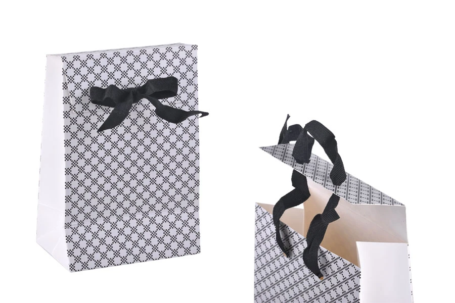 Paper gift bag in a special design and print with a 10mm grosgrain ribbon bow tie handle in size 105x67x150 Paper gift bag in a special design and print with a 10mm grosgrain ribbon bow tie handle in size 105x67x150