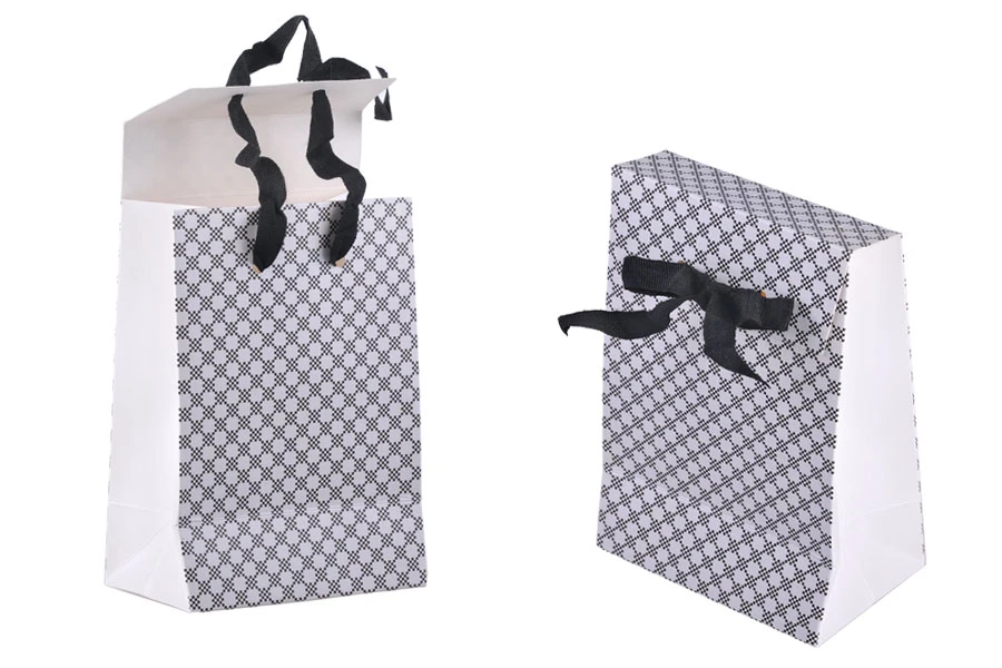 Paper gift bag in a special design and print with a 10mm grosgrain ribbon bow tie handle in size 105x67x150 Paper gift bag in a special design and print with a 10mm grosgrain ribbon bow tie handle in size 105x67x150