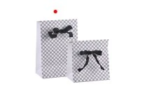 Paper gift bag in a special design and print with a 10mm grosgrain ribbon bow tie handle in size 105x67x150 Paper gift bag in a special design and print with a 10mm grosgrain ribbon bow tie handle in size 105x67x150