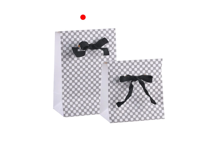 Paper gift bag in a special design and print with a 10mm grosgrain ribbon bow tie handle in size 105x67x150 Paper gift bag in a special design and print with a 10mm grosgrain ribbon bow tie handle in size 105x67x150
