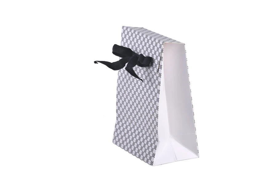 Paper gift bag in a special design and print with a 10mm grosgrain ribbon bow tie handle in size 105x67x150 Paper gift bag in a special design and print with a 10mm grosgrain ribbon bow tie handle in size 105x67x150