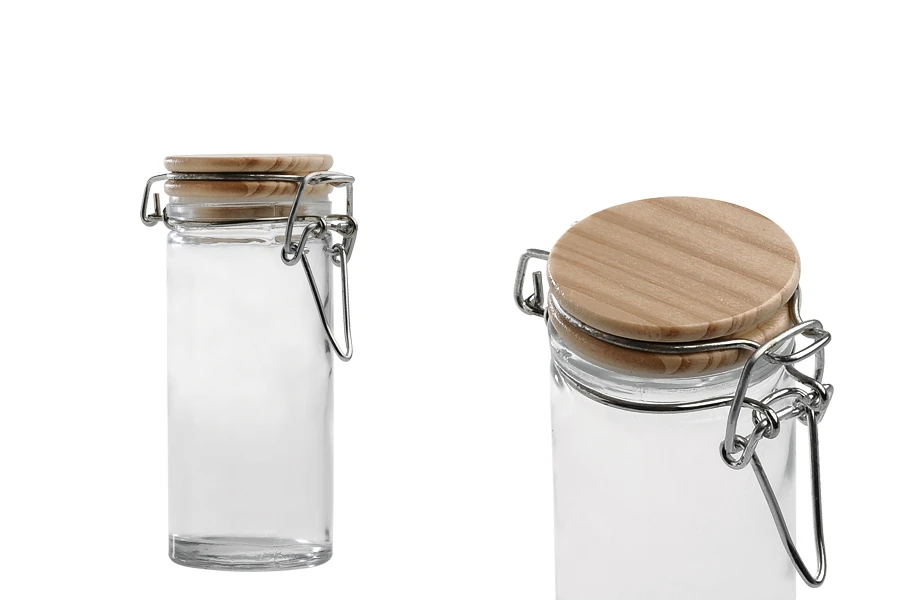 Barattolo tondo in vetro da 90 ml da 108x45 mm con tappo in legno e chiusura ermetica (filo e gomma sul tappo) Barattolo tondo in vetro da 90 ml da 108x45 mm con tappo in legno e chiusura ermetica (filo e gomma sul tappo)