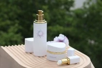 Lussuosa bottiglia in vetro da 100 ml di colore bianco opaco con tappo e pompetta per crema dorata-εικόνα_σύνθεση